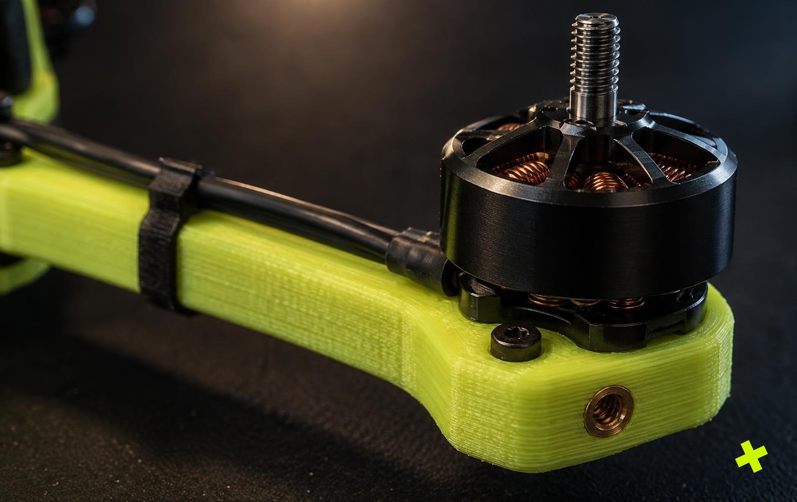 Detail van een geprinte dronearm met printlagen, messing draadinsert en motorwikkelingen